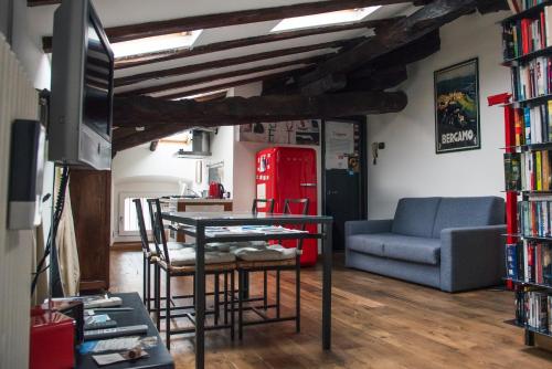 een woonkamer met een tafel en stoelen en een bank bij Casa Legami Charme & Relax in Bergamo