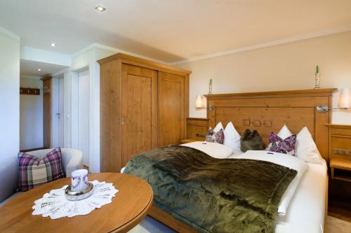 ein Schlafzimmer mit einem großen Bett und einem Tisch in der Unterkunft Chalet mySchlössl in Flachau