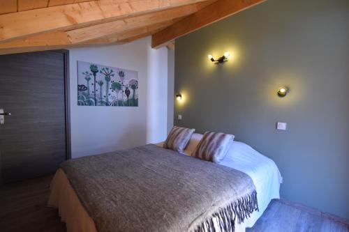une chambre avec un lit et un plafond en bois dans l'établissement VAUJANYLOCATIONS - Marguerite, à Vaujany