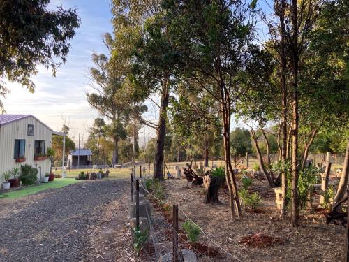 a fence in front of a yard with trees at Winganah Cottage in Murdunna