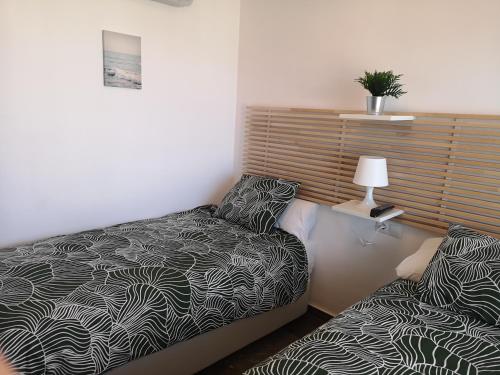 niewielka sypialnia z łóżkiem i lampką w obiekcie APARTAMENTO 1ª LINEA PLAYA GARAJE PISCINAS TERRAZA w mieście Torremolinos