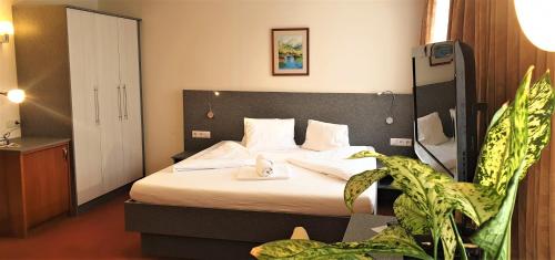 une chambre d'hôtel avec un lit et une plante dans l'établissement Gasthaus - Pension Kärntnerhof, à Faak am See