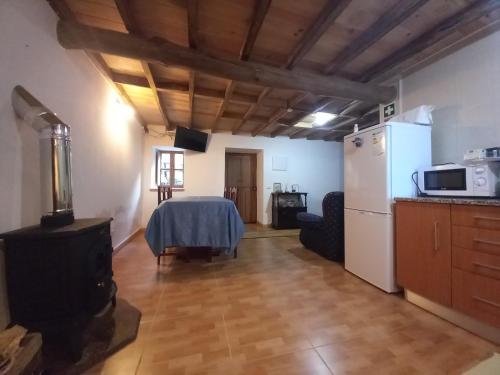 a living room with a table and a refrigerator at Casa da Esperança in Lousã