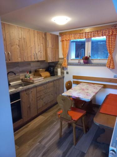 a kitchen with wooden cabinets and a table and a dining room at Apartment Tarman in Jesenice