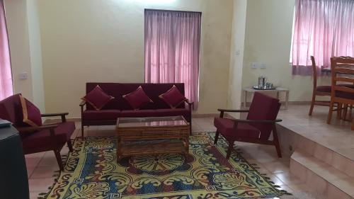 a living room with a couch and chairs and a table at Sunrise Villa in Kodaikānāl