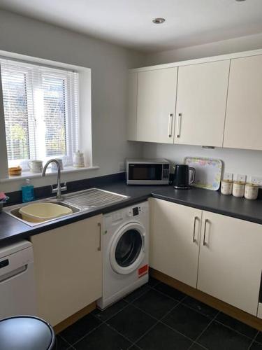 a kitchen with a sink and a washing machine at Abbotsleigh Rest - close to Glastonbury Abbey in Glastonbury