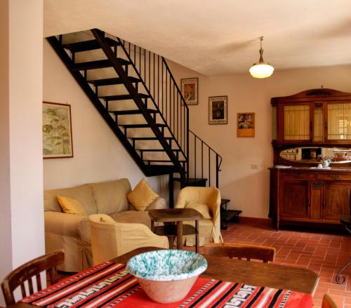 a living room with a couch and a staircase at Agriturismo Casa Greppo in San Venanzo