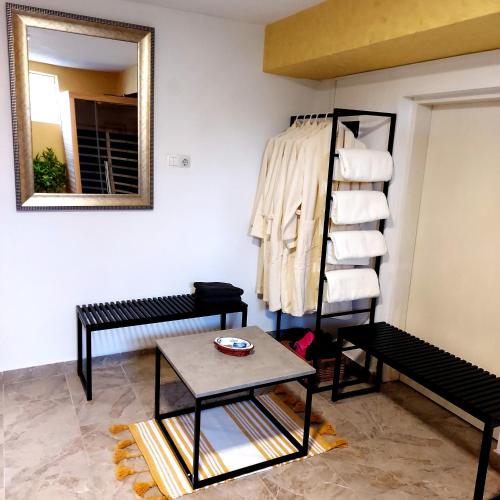 a room with a table and a shelf with towels at Odisea Hill House - Modern Holiday Home with swimming pool, sauna, jacuzzi, WiFi and 2 bedrooms, near Varazdin in Gačice