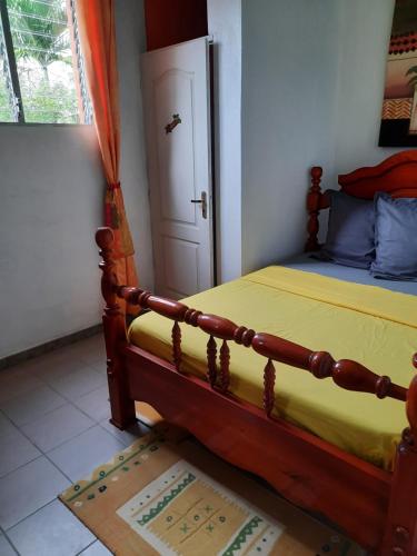 a bedroom with a wooden bed and a door at Chez Lilise 3 in Sainte-Anne