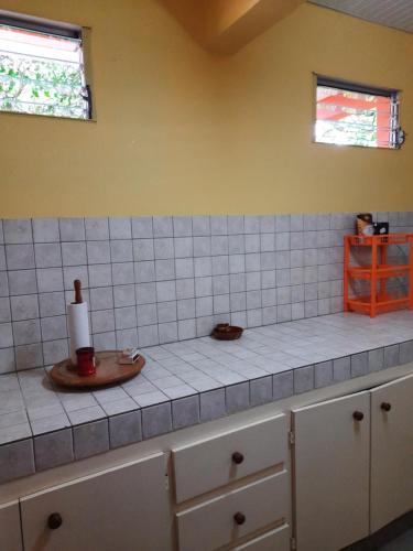 a kitchen with a counter top with white tiles at Chez Lilise 3 in Sainte-Anne