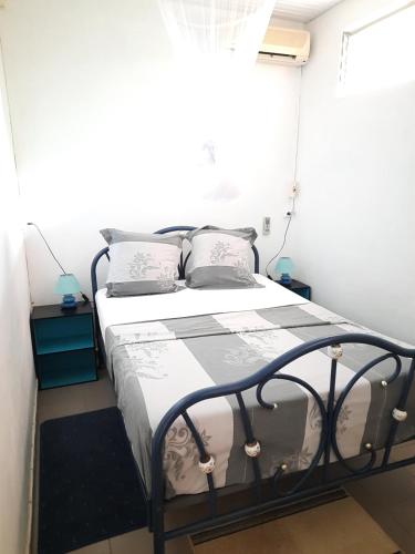 a bedroom with a bed in a white room at Chez Lilise 3 in Sainte-Anne