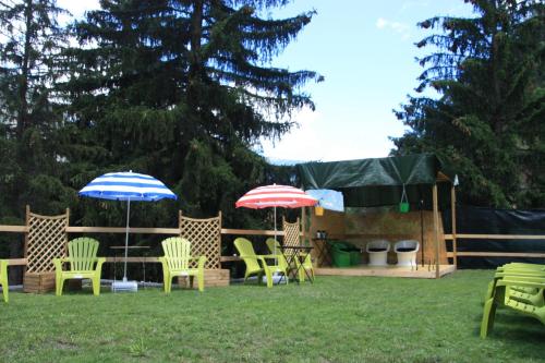 a group of chairs and umbrellas in a yard at Camping Du Parc in Pré-Saint-Didier