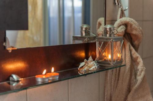 a bathroom with a mirror and candles on a shelf at Blue Pearl Villa in AmigdhalokeFálion
