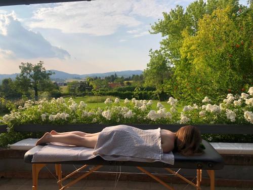 a woman laying on a bench in front of a garden at B&B Puntodivista in Chieri