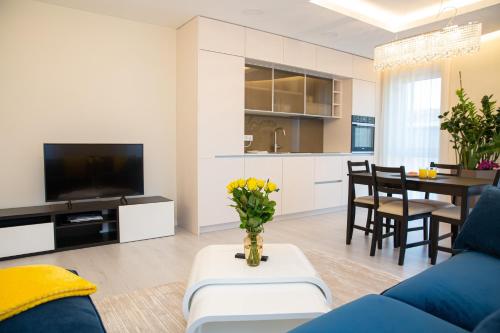 ein Wohnzimmer mit einem blauen Sofa und einem Tisch in der Unterkunft Luxurious Blue&Yellow Apartment in Kaunas Center in Kaunas