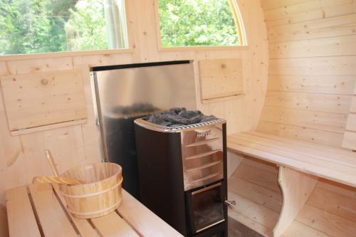 a black refrigerator sitting inside of a tiny house at Camping Du Parc in Pré-Saint-Didier