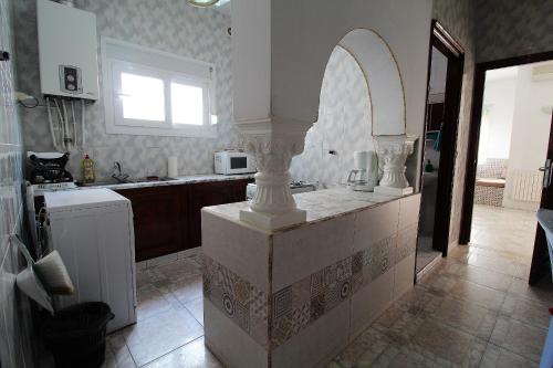 a kitchen with a counter with a sink and a window at Nice Holiday Apartment Hammam Sousse in Hammam Sousse
