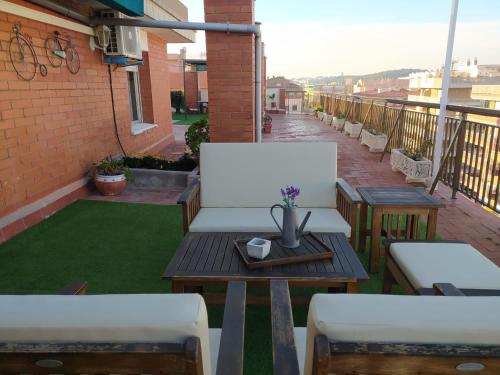 a balcony with two white chairs and a table with at Atico Isaac Albeniz in La Pineda