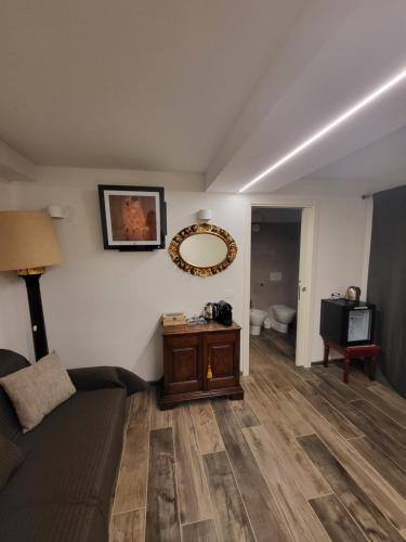 a living room with a couch and a mirror on the wall at Villa Torricelli Scarperia - Il Giardinetto Residence in Scarperia