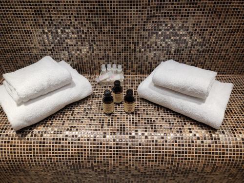 two towels and two bottles of soap on a bathroom counter at Villa Torricelli Scarperia - Il Giardinetto Residence in Scarperia