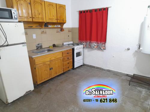 a kitchen with a white refrigerator and a red curtain at Duplex 17 - Santa Teresita - Grupo DEL SALVADOR in Santa Teresita