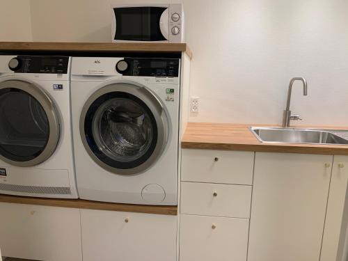 a kitchen with a washing machine and a sink at Spacious Apartment on N.P.Gøta 8a, Klaksvik in Klaksvík