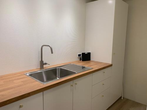 een keuken met een wastafel en een houten aanrecht bij Spacious Apartment on N.P.Gøta 8a, Klaksvik in Klaksvík