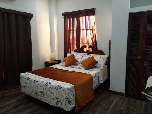 een slaapkamer met een bed en een raam bij Royal View Apartment Plus in Belize City