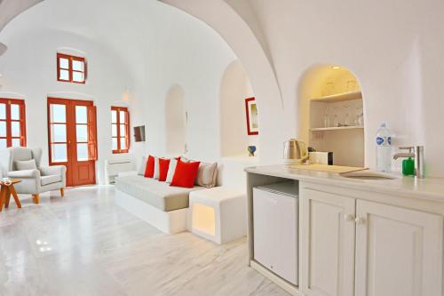 a kitchen and living room with a couch and a table at Oia Mare Villas in Oia