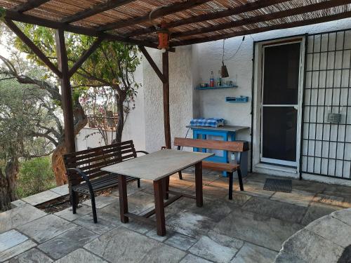 una mesa de picnic y dos bancos en un patio en VILLA IMELDA en Afissos