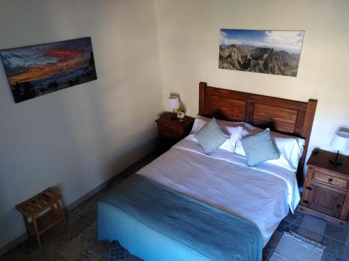 a bedroom with a bed and two paintings on the wall at Sustainable Rural House La Lisa Dorada in Agulo