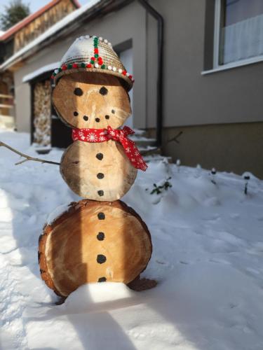 a fake snowman is standing in the snow at Chalupa Margareta in Telgárt