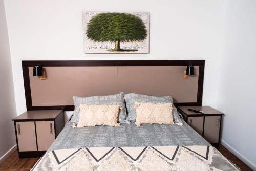 a bedroom with a bed with a tree above it at Hostal Tulvak Atacama in San Pedro de Atacama