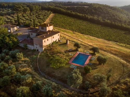 an aerial view of a house with a swimming pool on a field at Castello di Bossi in Castelnuovo Berardenga