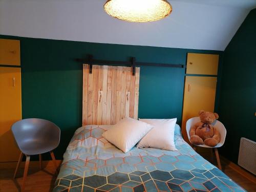 ein Schlafzimmer mit einem Bett, auf dem ein Teddybär liegt in der Unterkunft Chez Sophie et Thibault in Sceaux-du-Gâtinais