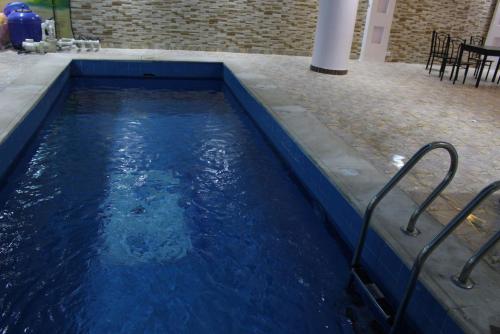 una piscina de agua azul con mesa y sillas en Al Rafahya Crown, en Riad