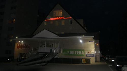 a building with a sign on the top of it at night at Guest House Comfort in Ufa