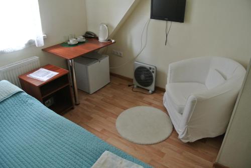 1 dormitorio con cama, escritorio y silla en Guest House Comfort, en Ufa