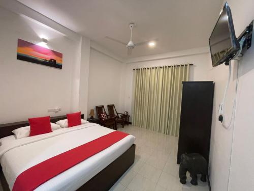 a bedroom with a bed and a tv on the wall at KITHULA Boutique Hotel in Hikkaduwa