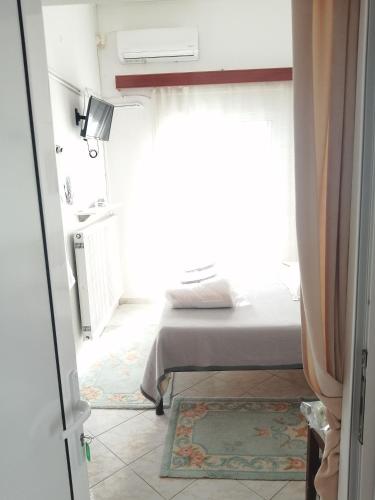 a bedroom with a bed and a window at Hotel Fotini in Kamena Vourla