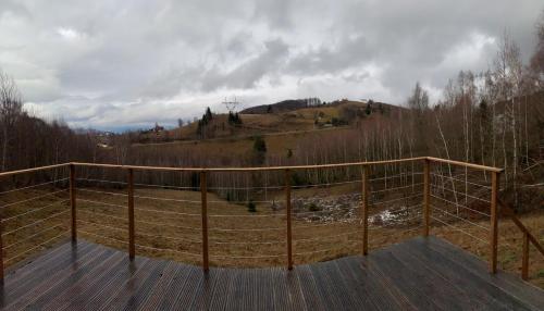 a wooden deck with a view of a mountain at AGLAS CHALET in Moieciu de Jos