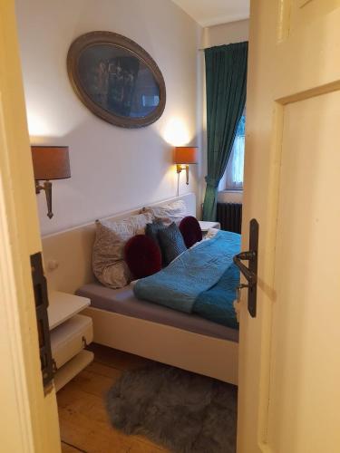 a bedroom with a bed with pillows and a mirror at Zlatá léta - apartmánový dům Jáchymov in Jáchymov