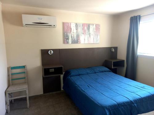 a bedroom with a blue bed and a chair at Lomas de Belgrano in Villa General Belgrano