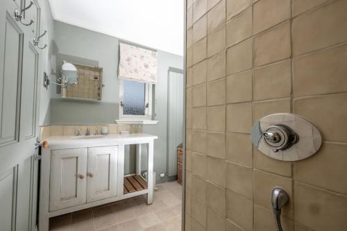 W łazience znajduje się umywalka i prysznic. w obiekcie Luxurious home overlooking Cruden Bay golf course w mieście Cruden Bay