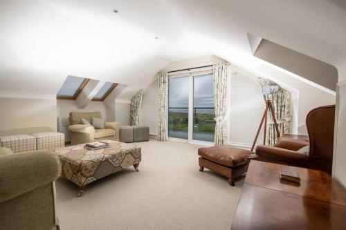 a living room filled with furniture and a large window at Luxurious home overlooking Cruden Bay golf course in Cruden Bay