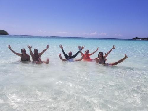 a group of people laying in the water on a beach at Ras Rana Lodge in Rasdu