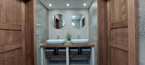 uma casa de banho com dois lavatórios e dois espelhos em VLADIMÍRA APARTMÁN TELGÁRT em Telgárt