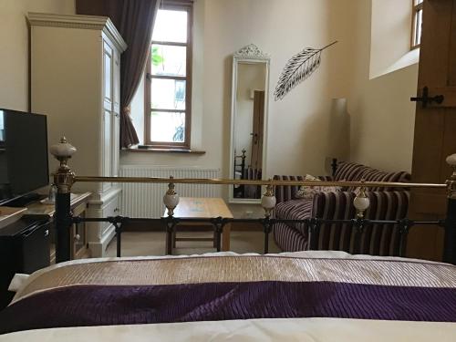 a bedroom with a bed and a living room at Old Chapel Forge in Chichester