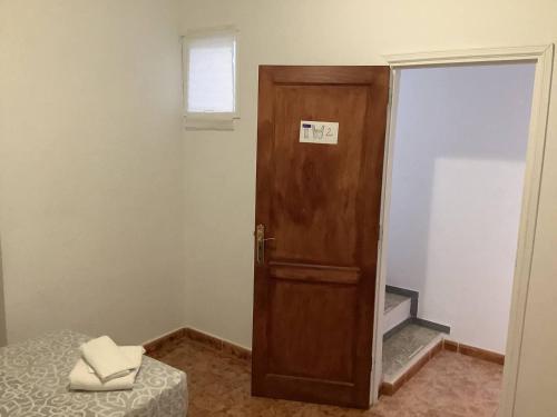 una camera con una porta, un letto e una finestra di Banana Surf House a Los Cristianos