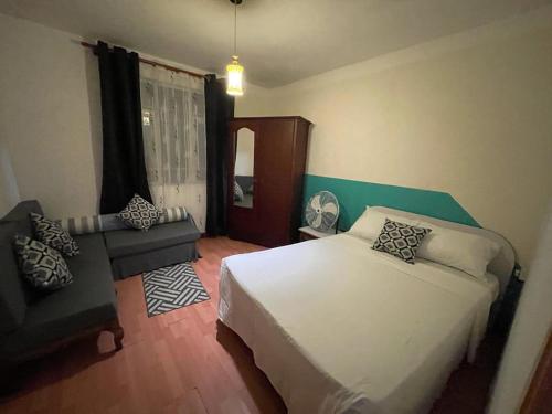 a bedroom with a white bed and a chair at pereyber 2 room appartment in Pereybere